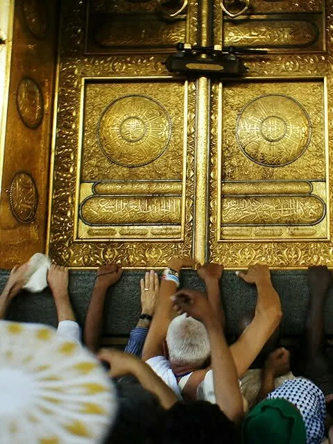 jb3e45 480x640 Muslim pilgrims reach to touch the golden doors of the kaaba