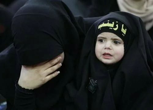 ashura_women_childen-Muslim-woman-holds-her-daughter-wears-a-head-band-with-Arabic.jpg