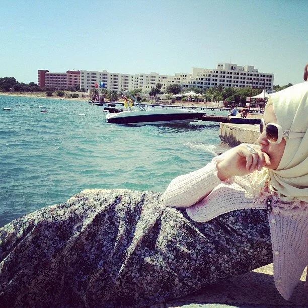 white rimmed sunglasses by the beach Woman in Light Pink Blouse and White Frame Sunglasses